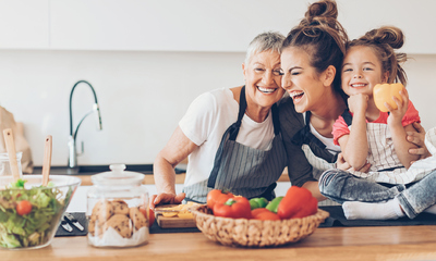 Three generations women laughing in the kitchen